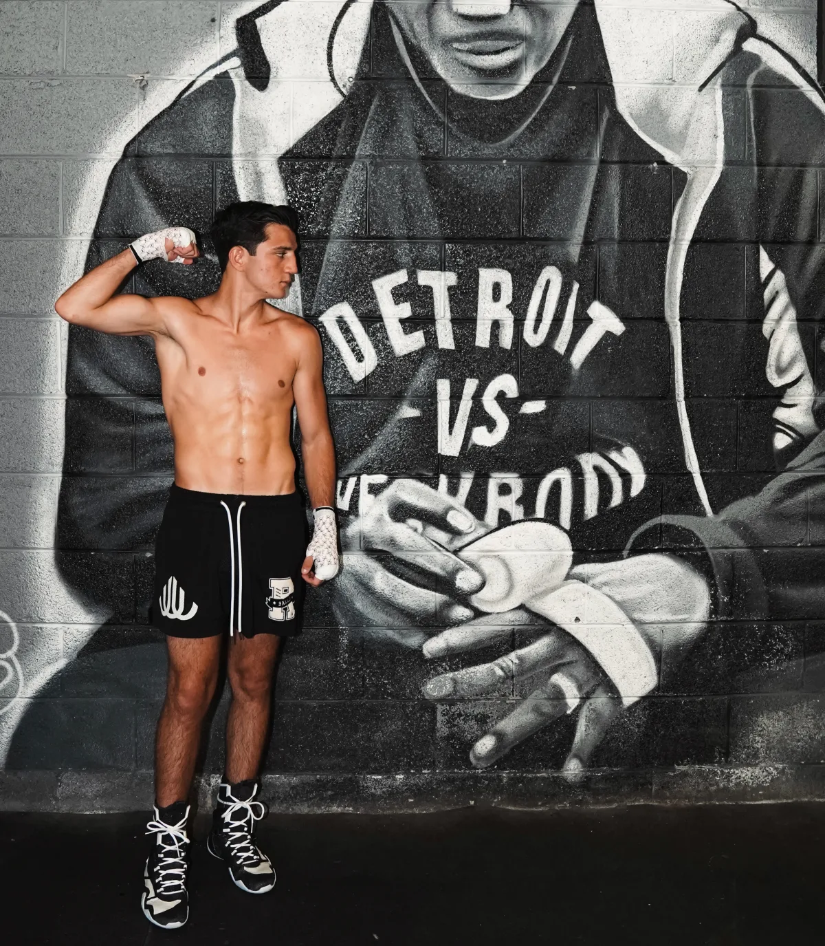 Julius Ballo in hand wraps in front of a Detroit vs Everybody mural