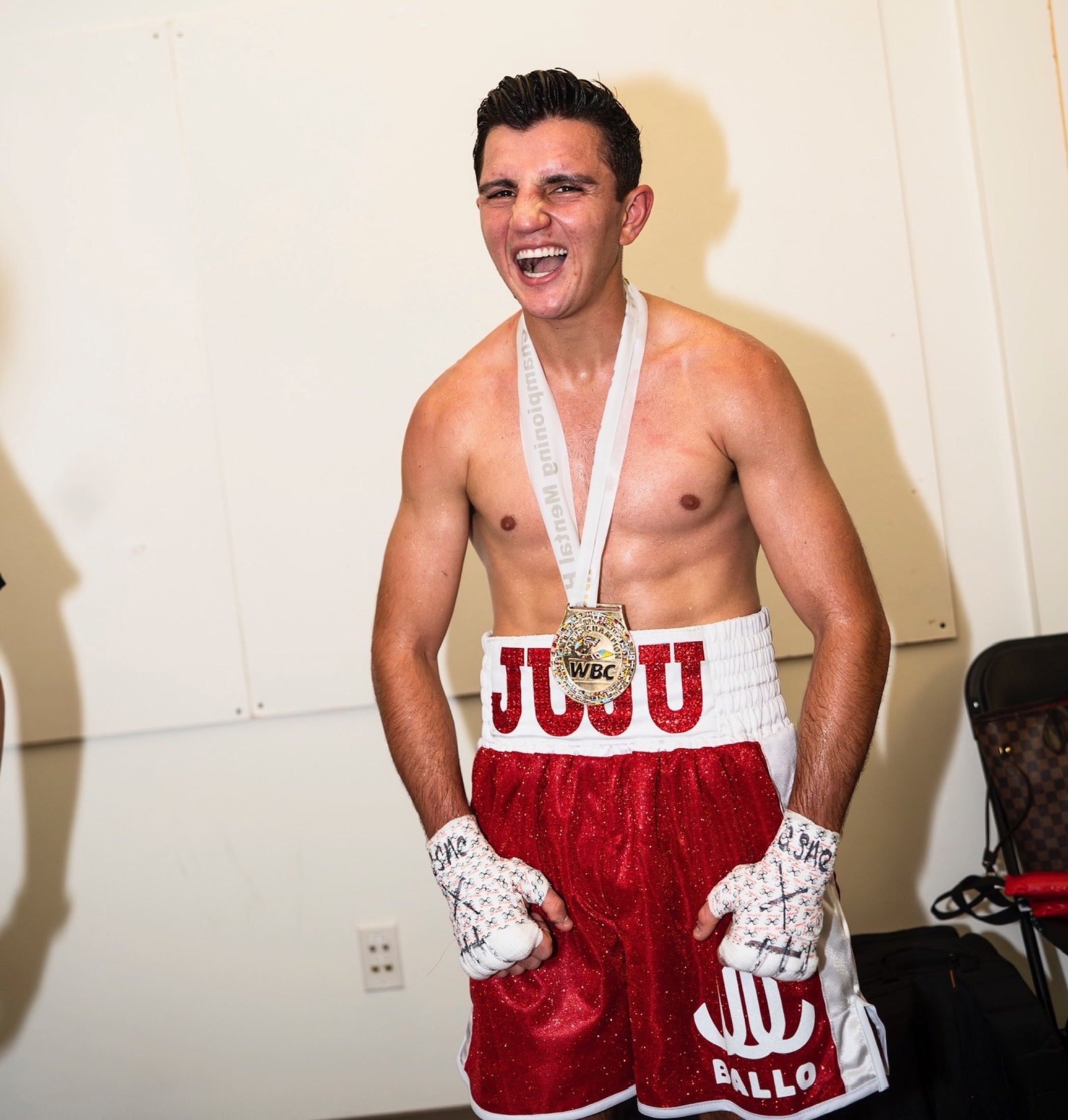 Julius Ballo with a gold medal around his neck in his red JUJU trunks